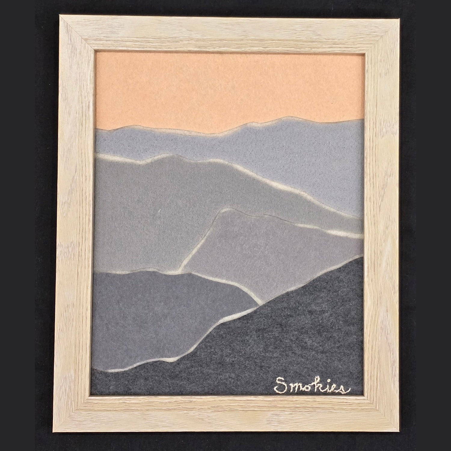 Framed handmade felt artwork depicting the Smoky Mountains with layered shades of gray and peach. A unique nature-inspired wall decor piece.