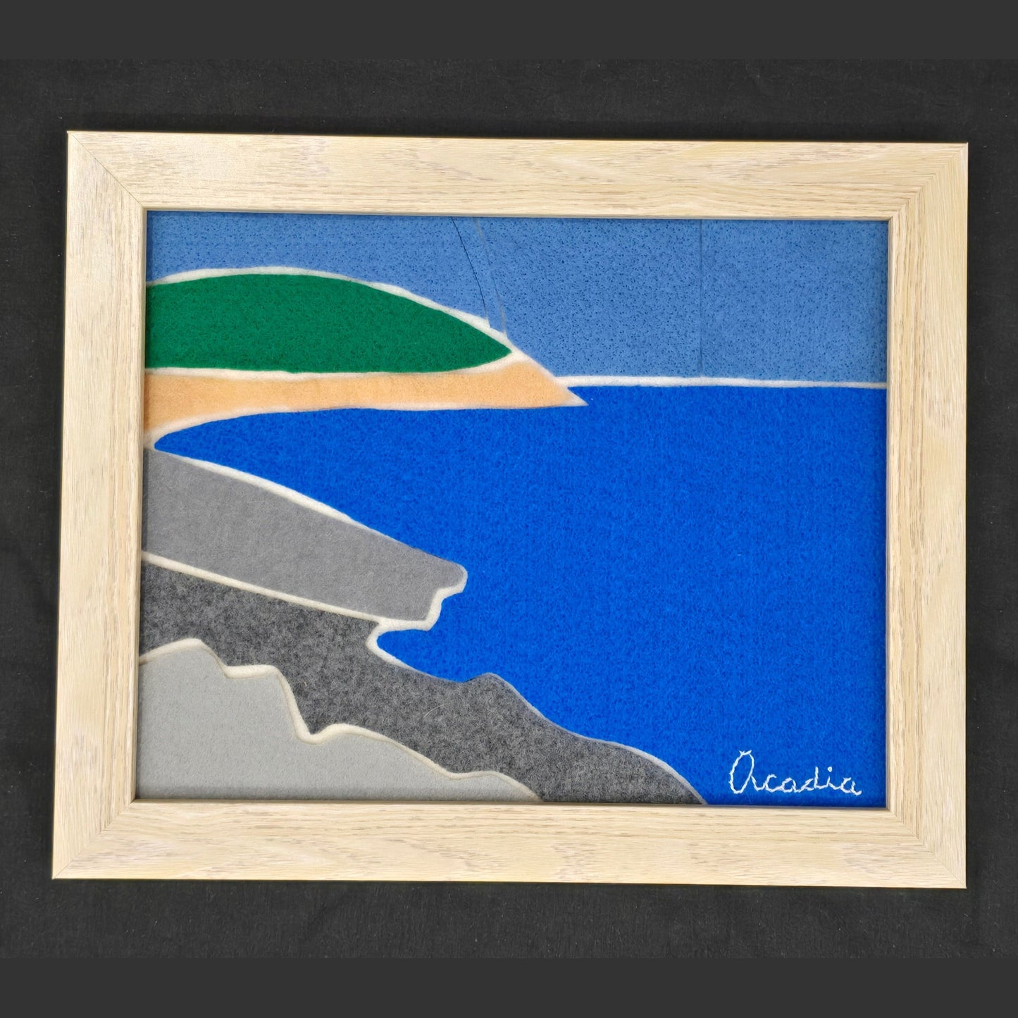 Handmade felt artwork of Acadia National Park featuring blue waters, golden beaches, and rocky coastlines, with 'Acadia' embroidered for a unique touch.
