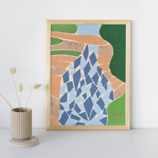 Abstract waterfall in neutral frame leaning against white wall with vase with four stems sticking out of it.