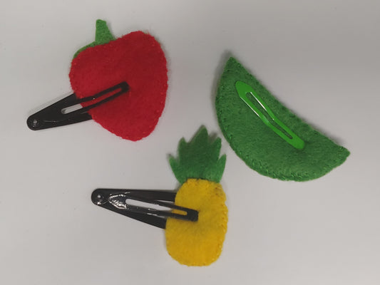 Handmade felt fruit hair clips featuring Watermelon, Pineapple, and Strawberry designs on metal snap clips. A playful, colorful accessory for all ages. Back of clip.