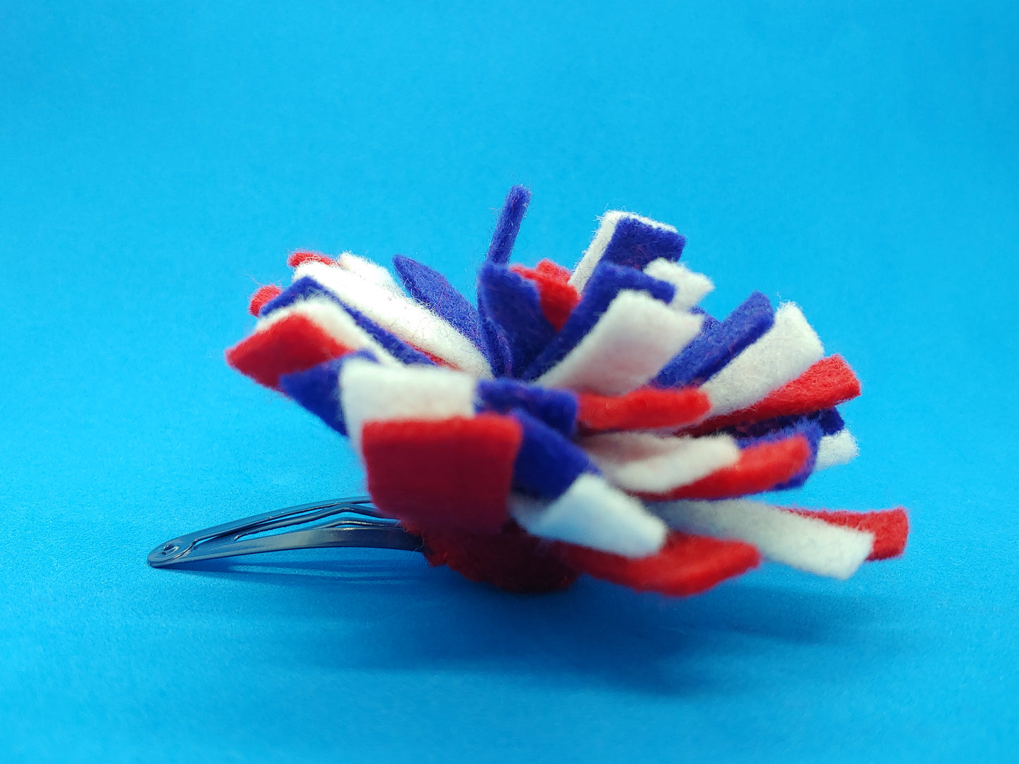Handcrafted Patriotic Firework Felt Hair Clip in red, white & blue on a secure metal snap clip. A fun 4th of July & USA pride accessory.