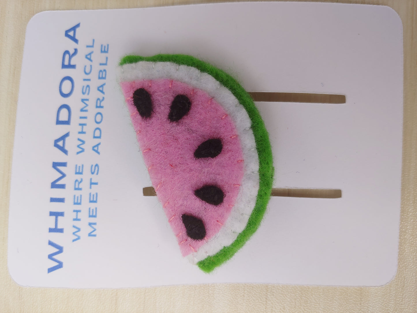 Handcrafted Watermelon Felt Hair Clip featuring bright pink, green, black, and white felt with a secure snap clip. A fun summer accessory.