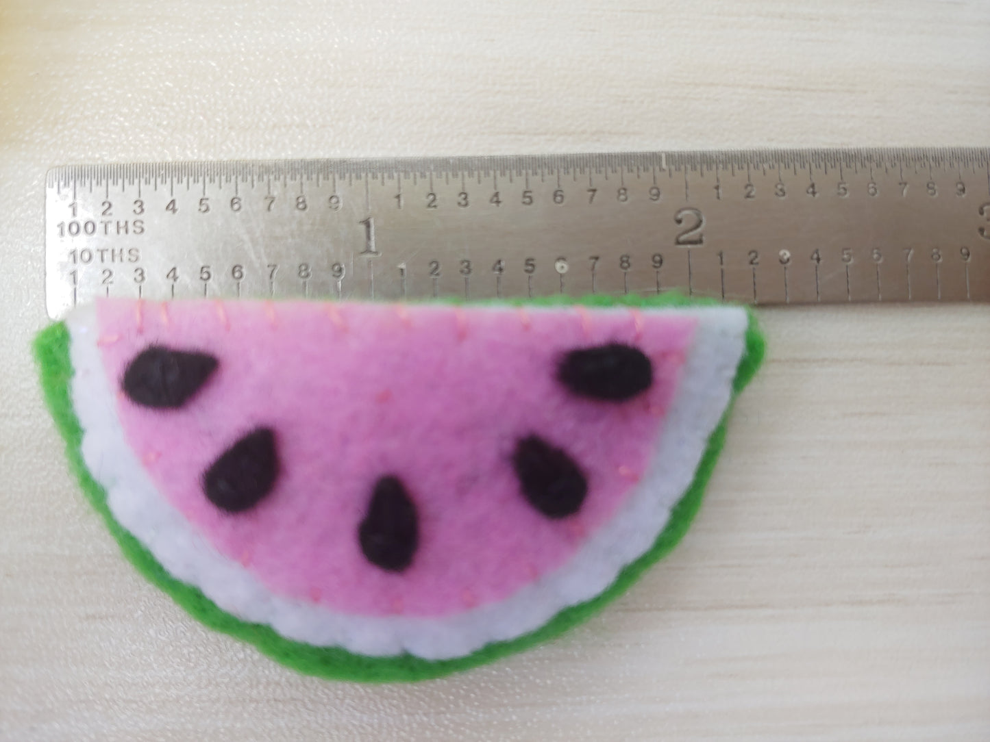 Handcrafted Watermelon Felt Hair Clip featuring bright pink, green, black, and white felt with a secure snap clip shown with ruler. A fun summer accessory.