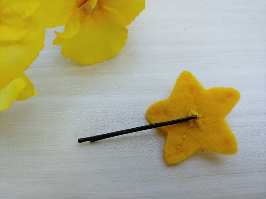 Handcrafted Star Felt Hair Clip featuring a cheerful smile, bright yellow felt, and a secure black bobby pin - reverse side. A fun, quirky hair accessory.