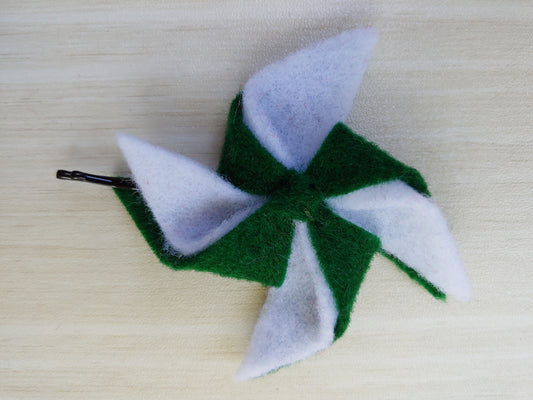 Green and white pinwheel felt hair clip on a bobby pin